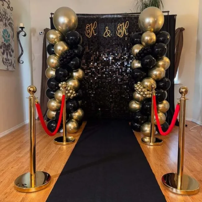 Black birthday event carpet with gold stanchions