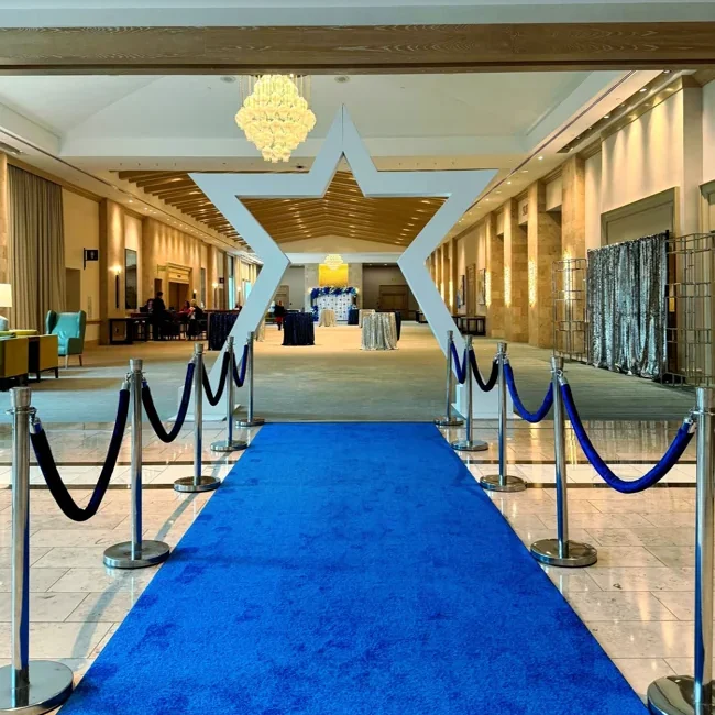 Blue exhibition carpet runner leading towards arch