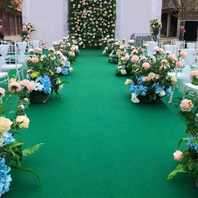 Green carpet aisle decorated with colorful flowers
