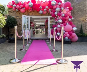 Pink carpet entrance leading to balloon arch
