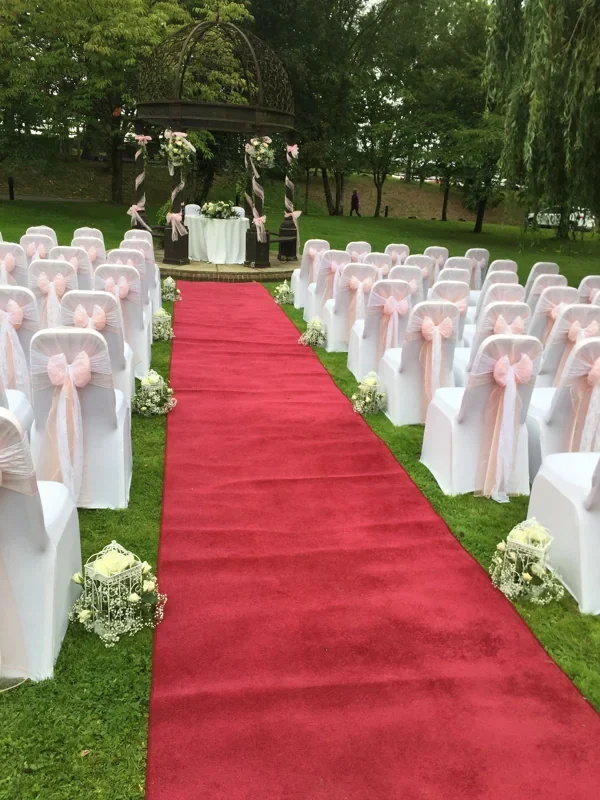 Red event carpet aisle on grass